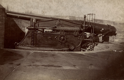 Sepia-tone photo, showing details of a 10-inch gun and the engine platform in an unknown battery at the fort.