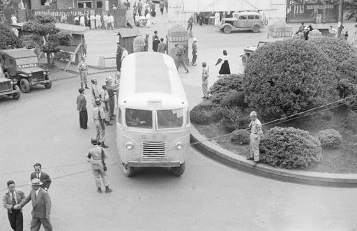 Military police inspecting a National Assembly commuter bus in front of the Provisional Capital Government Building