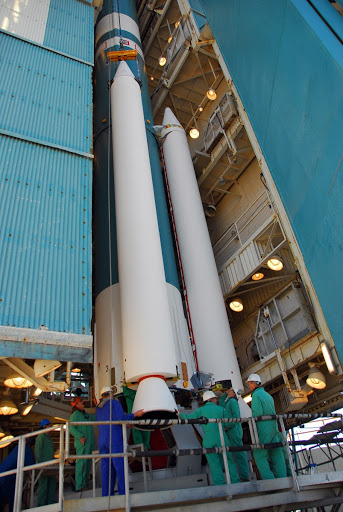 Workers attach one of three solid rocket motors to a United Launch Alliance Delta II launch vehicle at Vandenberg Air Force Base in California.