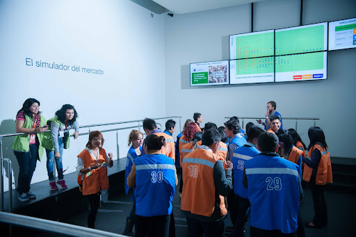 Visitantes viviendo la experiencia del Simulador de mercado