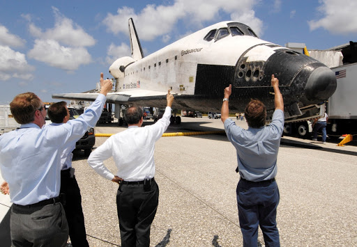 NASA Administrator Michael Griffin center and NASA managers give thumbs up signals to the crew of the Space Shuttle Endeavour.