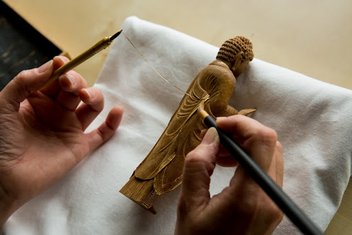 Applying thin cut gold leaf, Kirikane