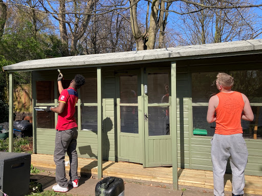 Richmond House residents painting the shed in the hostel garden.