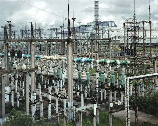 Transmission lines and high-voltage power transformers with the Chernobyl nuclear power plant in the background