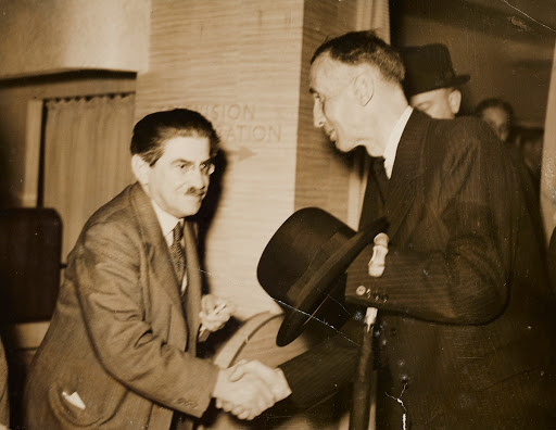 Sir Isaac Shoenberg greeting unknown man