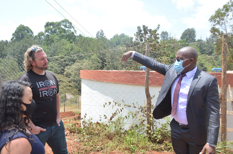 Members of the Can Do Kids NGO with Muwasco MD Daniel Ng'ang'a at the 300,000- litres Karechiungu water tank.