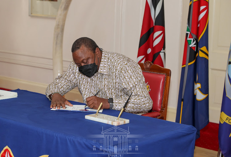 President Uhuru Kenyatta signs the Refugees Bill, Foreign Service Bill and the Law of Succession (Amendment) Bill into law at State House, Nairobi, on November 17, 2021.