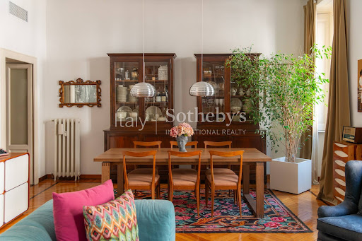 Dining room with wooden table and chairs in this luxury apartment / penthouse for sale in Milan ($1,214,659 - 135 m²)