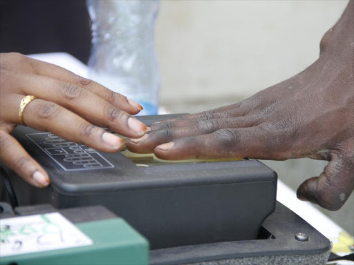 An IEBC official takes a voter's finger print details during a voter registration exercise at Pumwani social hall as mass voter registration kicked off countrywide. /FILE