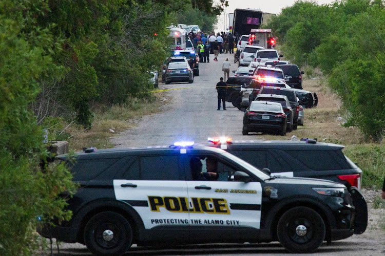 Law enforcement officers work at the scene where people were found dead inside a trailer truck in San Antonio, Texas, U.S. June 27, 2022.