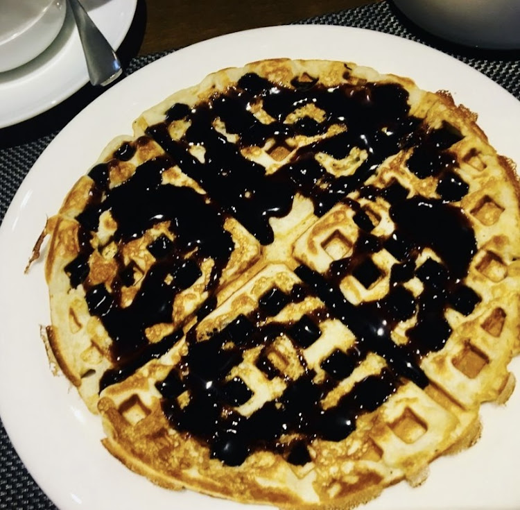 Fluffy waffles drizzled with chocolate syrup on top