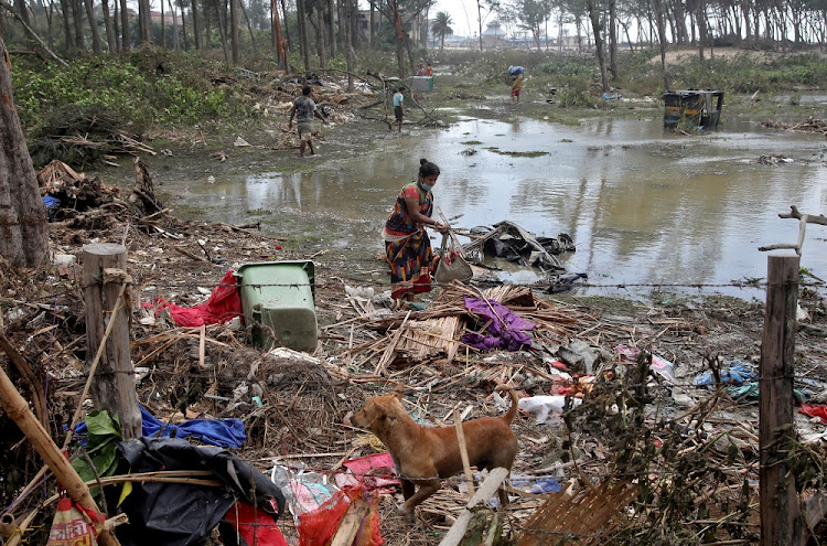 A woman salvages her belongings near her damaged hut following Cyclone Yaas in Digha, Purba Medinipur district in the eastern state of West Bengal, India, May 27, 2021.