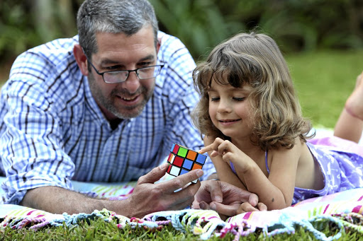 Zoe Grove learns to solve a Rubik's Cube with her father Leon Grove.