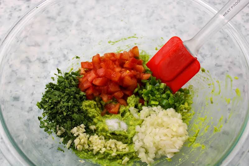 Stirring In Cilantro, Chopped Onion, Tomato, Chopped Garlic, Serrano Chilies, And Salt.