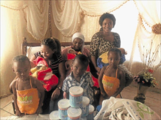 KINDNESS OF STRANGERS: Tshidi Mholo (in leopard print dress) and her niece Lesego Matabane visit Rebecca Phejane and her two sets of triplets at their home yesterday. Photo: Boitumelo Tshehle