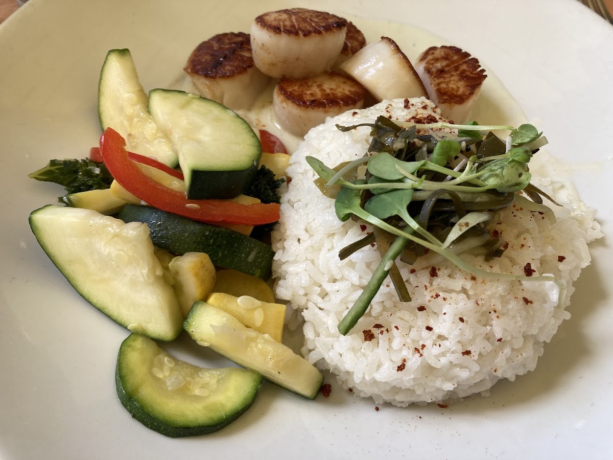 Seared scallops with wasabi cream sauce, sticky rice with seaweed/cucumber slaw, and seasonal vegetables.