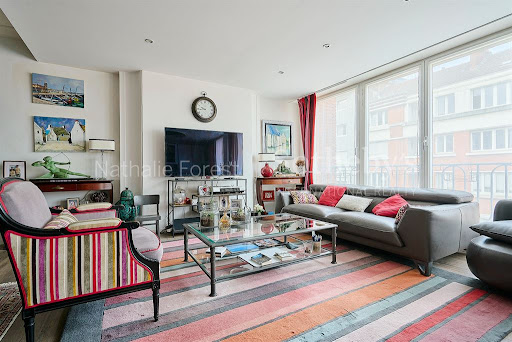 Living room with grey sofa and colorful rug in this luxury property for sale in Lille ($578,336 - 100 m²)
