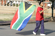 EFF supporter carries a South African flag as she marches at Pretoria Church Square  