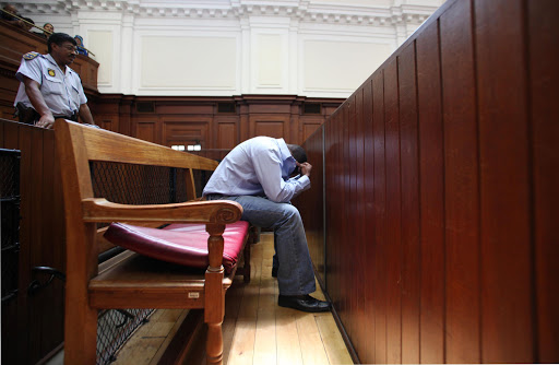 Zola Tongo, the shuttle bus driver, hides his face inside the Cape High Court. Pic: Shelley Christians. 07/12/2010. © The Times