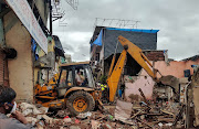 Rescue workers search for survivors in the debris after a residential building collapsed in Mumbai, India, on June 10 2021. 