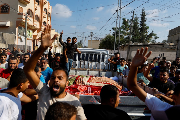 People transport the bodies of Palestinians from the Samour family, who were killed in Israeli strikes on their house, to bury them at a land near to their home as the residents struggle to find spaces in cemeteries, in Khan Younis in the southern Gaza Strip, on October 12 2023. Picture: IBRAHEEM ABU MUSTAFA/REUTERS