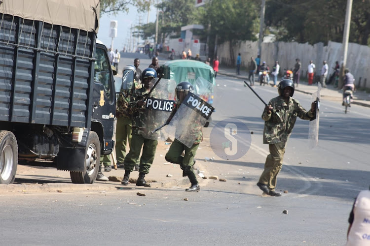 Police officers react when protesters were hauling stones at them at Kisumu Boys round-about on July 19, 2023.