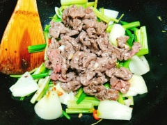 Vẫn là chảo đó, thêm 2 muỗng canh dầu ăn vào chảo đun cho nóng rồi cho nốt chỗ tỏi băm vào phi thơm. Sau đó, cho hành tây vào xào sơ qua, thêm cần tây, hành lá, ớt sừng vào xào cùng, nêm 1 muỗng cà phê hạt nêm cho vừa miệng.