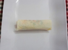 Trải bánh tráng bía ra, cho hỗn hợp cà rốt, hành tây vào, cuốn tròn lại.