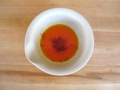 Chuẩn bị bột nghệ, bạn có thể nghiền nhuyễn bột nghệ với muối, sau đó khuấy đều với nước nóng và nhụy hoa nghệ tây. Trong lúc đó, bạn vo sạch gạo. Bắc nồi dầu ăn lên bếp, cho hành tây vào phi thơm, sau đó cho gạo vào xào.