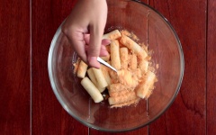 Cho bánh gạo đã chiên vào tô. Rắc đều bột phô mai vào, lắc đều là có ngay bánh gạo chiên lắc phô mai rồi nhé.