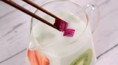 Sắp các hũ nhỏ ra. Xếp kiwi, khoai tây dọc thành hũ sao cho đẹp mắt rồi đổ sữa chua vào từ từ đến khi ngập mặt trái cây. Cho thanh long cắt khối lên trên mặt. Làm tương tự đến khi hết yoghurt và trái cây.