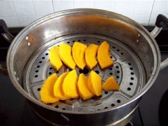 Chuẩn bị làm bánh bí đỏ: Gọt vỏ bí đỏ, rửa sạch, cắt bí thành từng miếng khoảng 1cm. Cho các miếng bí đỏ vào xửng hấp, hấp chín.