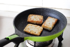 Làm nóng chảo với chút dầu ăn láng mặt, đợi dầu thật nóng rồi mới thả miếng cơm vào áp chảo. Áp chảo một mặt bánh thật xém vàng mới lật lên để chiên nốt mặt còn lại.