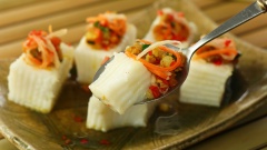 Cho bánh đã cắt ra đĩa, rải đều phần nhân lên bánh. Món bánh đúc mềm ngon, hấp dẫn và thơm vị nước cốt dừa, lại có nước chấm chua ngọt cho món ăn thêm đậm đà.