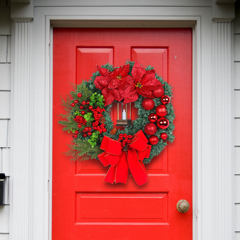 Christmas wreath with decorative lantern and red flowers