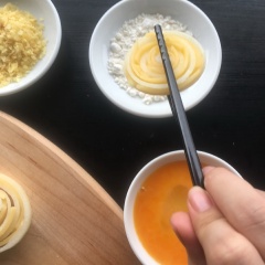 Bây giờ, bạn lăn khoanh hành tây qua 50gr bột mì, 1 quả trứng khuấy tan và 50gr bột chiên xù. Nếu dùng snack khoai tây rồi giã nhuyễn ra sẽ ngon hơn bạn nhé. Sau đó, bạn cho khoanh hành tây vào khay nướng và nướng trong 15 phút ở nhiệt độ 180 độ C. Bạn có thể thêm 1 chút lá thyme trên bề mặt để bánh thêm hấp dẫn nhé.