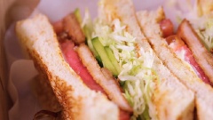 Quết mayonnaise lên miếng bánh mì còn lại, đặt vài lát cà chua và xếp lên miếng bánh trước đó. Sau khi cố định hai lát bánh bằng tăm, dùng dao lưỡi mỏng và sắc cắt bánh mì làm đôi.