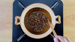 Làm nóng 2 muỗng canh dầu olive, cho vào 1 muỗng canh đường trắng, dùng đũa khuấy đều cho tan đường. Khi đường chuyển sang màu vàng caramel và sôi nhẹ thì cho 20gr hành boa rô băm nhuyễn (phần thân xanh) vào, phi hành cho vàng thơm. Tiếp theo đổ hỗn hợp nước kho đã pha vào nồi, đun sôi.