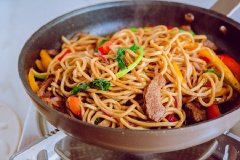 Thêm ớt chuông, hành tây, cải bó xôi và mì vào đảo đều cho nguyên liệu chín là xong.