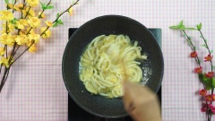 Bắc chảo lên bếp, cho dừa trộn vào, sên lửa nhỏ, đảo đều tay trong vòng 20 phút đến khi nước sầu riêng kẹo lại và bám đều vào miếng dừa non. Tắt bếp, rãi thêm mè rang lên mứt dừa.