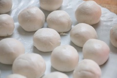 Chia bột thành những phần bằng nhau, vê tròn rồi ấn dẹt, cho nhân đậu đỏ vào giữa và gói kín lại. Làm lần lượt đến khi hết bột.