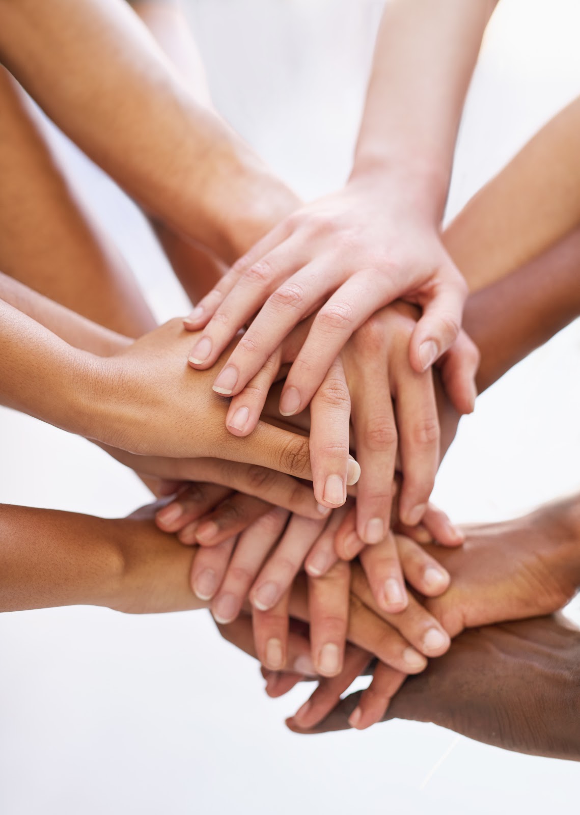 Manos de varias personas reunidas, símbolo de la accesibilidad y la solidaridad de los servicios Adéquat
