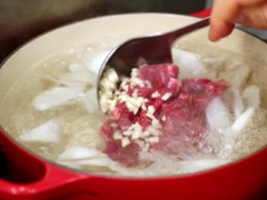 Tiếp theo, cho thịt bò, tỏi băm vào cùng. Nêm 1 muỗng cà phê nước mắm, 1 muỗng cà phê muối và 1 muỗng cà phê hạt nêm vào, nấu thêm khoảng 5 phút.