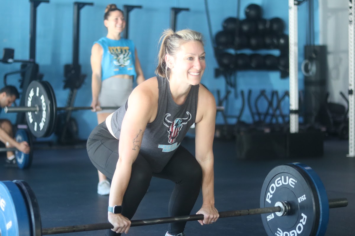 OxFit members training together, teammate cheering a deadlift