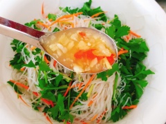 Đun nóng 1 muỗng canh dầu ăn. Cho tôm vào xào chín. Cho miến, cà rốt, hành tím, rau vào tô lớn trộn đều. Rưới nước sốt lên rồi trộn cho thấm.