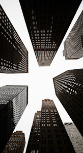 Extreme Low Angle Looking Up at a Cluster of Converging Skyscraper Facades Against Sky