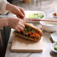 Bổ đôi nửa ở bánh mì nhưng không cắt rời, phết vào hỗn hợp sốt tương cà, sốt mayonnaise và siro bắp. Sau đó nhồi vào đồ chua, thịt gà, ớt và ngò rí là có thể dùng.