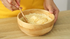 Cho 2 quả trứng gà vào tô 400gr cơm nguội cùng 2 muỗng cà phê hạt nêm Maggi, trộn đều.