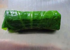 Lá lốt trải lên dĩa, mặt gân phía trên, cho ít thịt lươn vào cuộn tròn lại ghim cuốn lại cho khỏi bung.