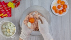 Thịt gà xay mịn cho vào tô chung với giò sống, cho thêm các loại gia vị: 15gr đầu hành trắng băm nhỏ, 15gr gốc ngò rửa sạch băm nhỏ, 2 muỗng canh hạt nêm, 1 muỗng canh nước mắm, 1 muỗng canh đường, 1 muỗng canh bột năng, 1/2 muỗng cà phê bột nở và 2 muỗng canh dầu ăn để tạo độ bóng và độ dai cho viên gà. Quết đều hỗn hợp nhiều lần cho dai hơn. Lấy vỏ thịt gà bọc lần lượt trứng muối và trứng cút thành những viên tròn.